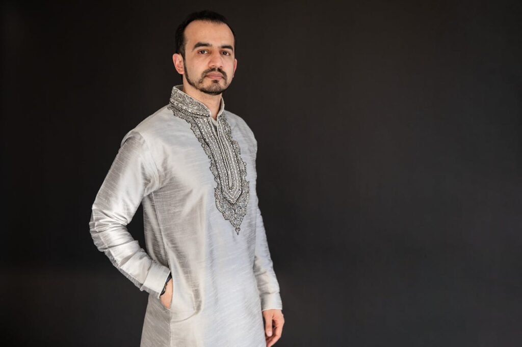 Home Portrait of a man in traditional clothing against a dark background.